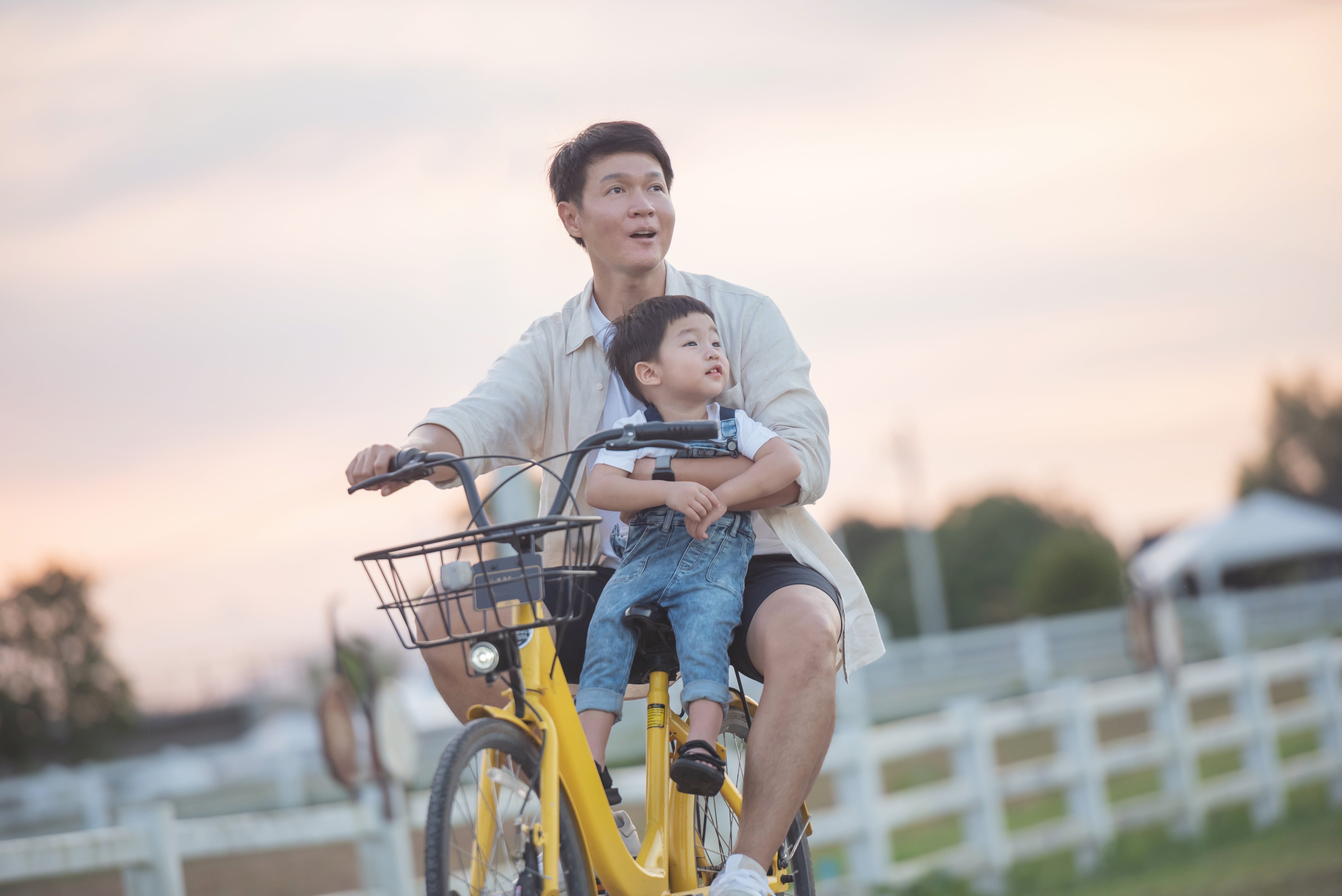 portrait of happy young father and son on a bike